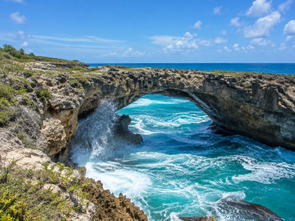 Natural rock arch with waves crashing beneath